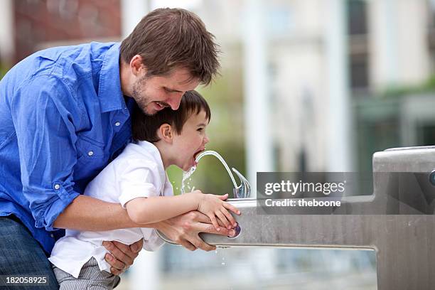 young family in an urban park. - drinking fountain stock pictures, royalty-free photos & images