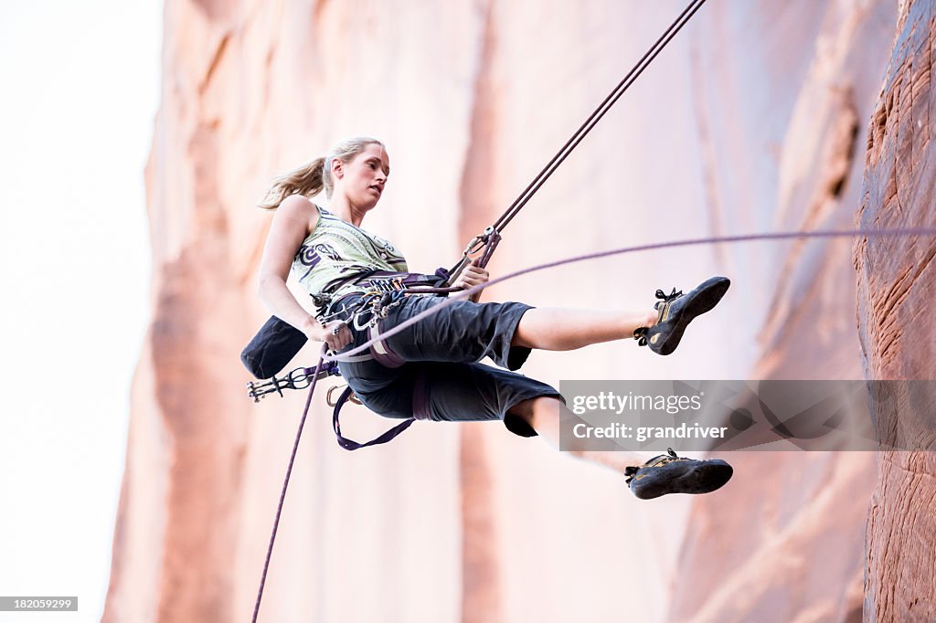 Young Woman Rock Climber on a sandstone cliff