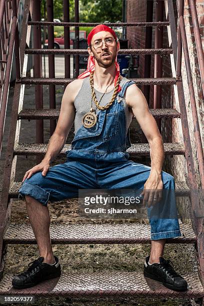 1990s hip-hop goofy nerd guy with bling in dark alley - chain link stock pictures, royalty-free photos & images