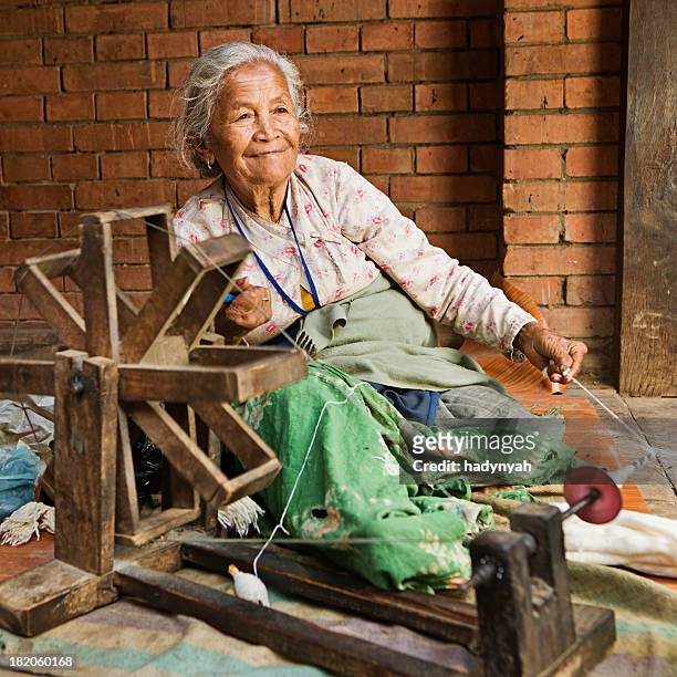 nepali frau spinning der wolle.   bhaktapur - spinnrad stock-fotos und bilder