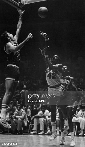 American basketball player Spencer Haywood, New York Knicks power forward, shoots under pressure from American basketball player Brian Winters,...