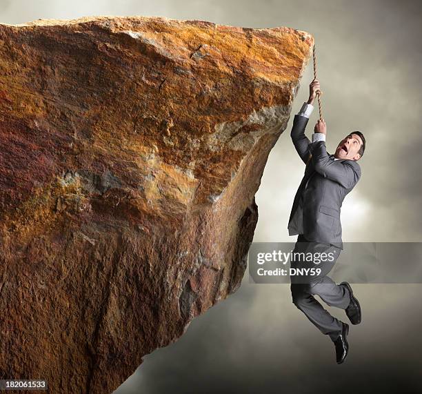 businessman hanging from rope off of a cliff - suits hanging stock pictures, royalty-free photos & images