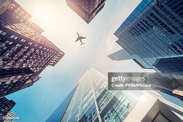 wolkenkratzer mit einer flugzeug-silhouette - america travel stock-fotos und bilder