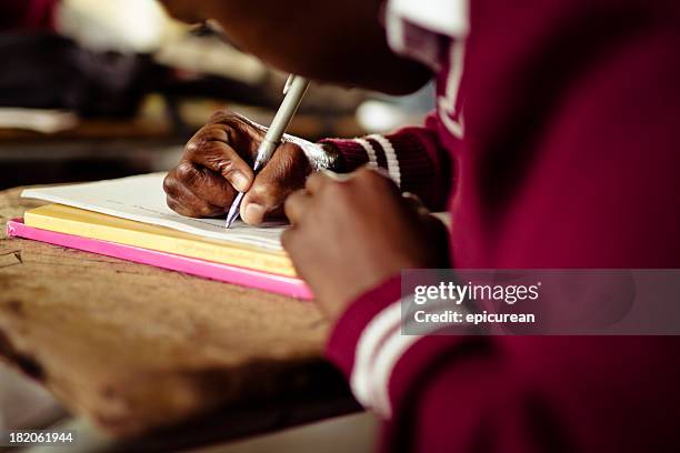 closeup image of south african girl writing at her desk - south african culture stock pictures, royalty-free photos & images