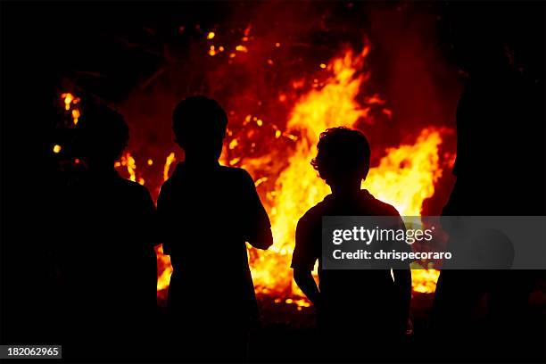 children gazing at a raging bonfire in the dark - arson stock pictures, royalty-free photos & images