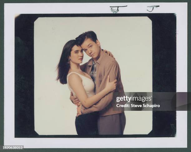 Portrait of American actors Jennifer Connelly and Frank Whaley, as they embrace in front of a white background, for the film 'Career Opportunities' ,...