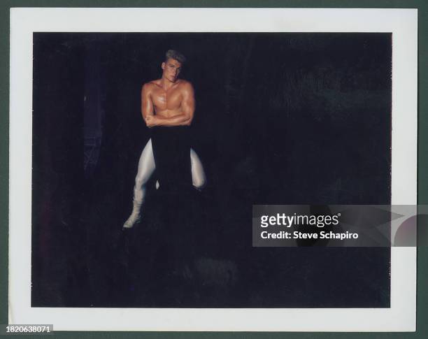 Portrait of Swedish actor Dolph Lundgren, shirtless, as he kneels on a chair, during a photo shoot for the film 'Rocky IV' , Los Angeles, California,...