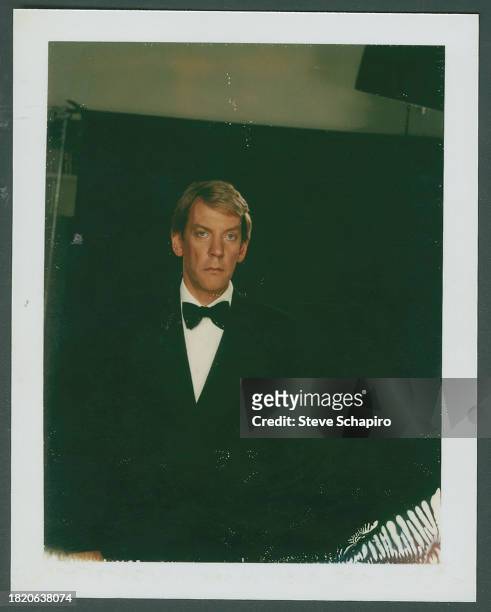 Portrait of Canadian actor Donald Sutherland, in a dinner jacket and bowtie, as he poses against a black background, Los Angeles, California, 1982.