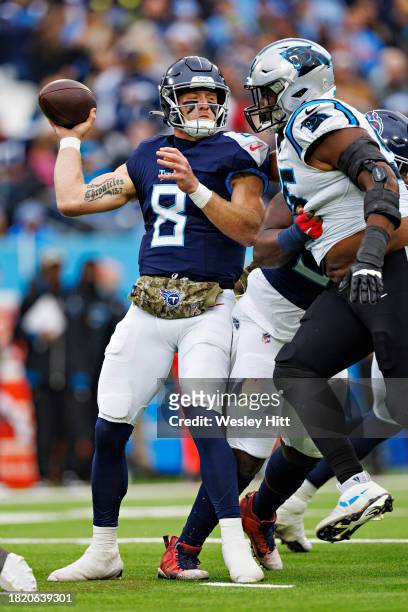 Will Levis of the Tennessee Titans throws a pass under pressure from Derrick Brown of the Carolina Panthers at Nissan Stadium on November 26, 2023 in...