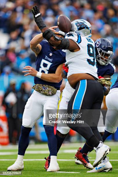 Will Levis of the Tennessee Titans throws a pass under pressure from Derrick Brown of the Carolina Panthers at Nissan Stadium on November 26, 2023 in...