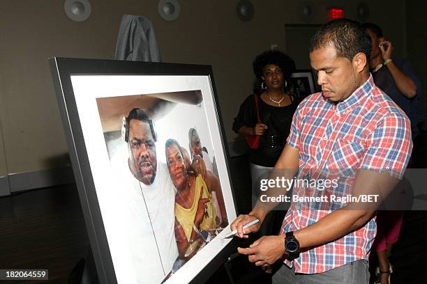 Photographer Johnny Nunez signs one of his photographs at the BET Music Matters "Press Play" event Powered by Monster at TWELVE Atlantic Station on...