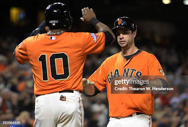 Brandon Belt of the San Francisco Giants is congratulated by Tony Abreu after hitting a two-run home run during the third inning against the San...