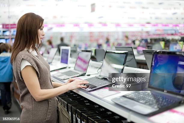 woman chooses the laptop - electronics stockfoto's en -beelden