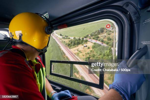 side view of man driving vehicle - helicopter cockpit stock pictures, royalty-free photos & images