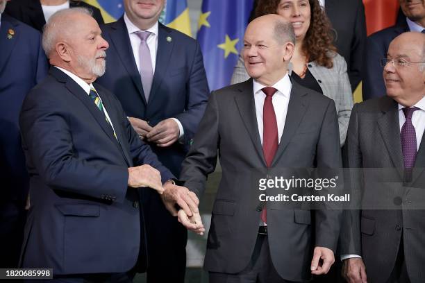 Brazilian President Luiz Inacio Lula da Silva takes the hand of German Chancellor Olaf Scholz during a family photo of heads of state at the...