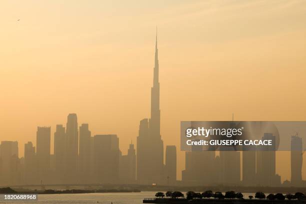 Haze obscures the Dubai skyline including Burj Khalifa, the world's tallest building on December 4, 2023. The United Arab Emirates is choking under...