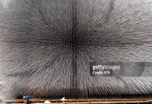 Chinese worker goes about his chores at the construction of the Seed Cathedral, the centerpiece of the United Kingdom Pavilion at the Shanghai World...