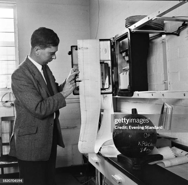 Bruce Elsmore of the Radio Astronomy Group reads a graph showing radio signals from the Soviet satellite 'Sputnik', Cambridge University, October...