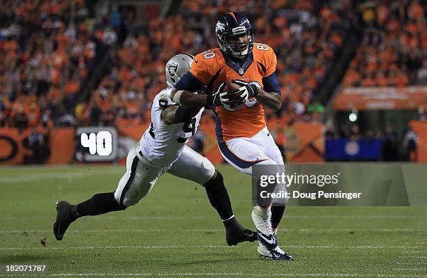 Julius Thomas of the Denver Broncos sheds Kevin Burnett of the Oakland Raiders for a touchdown reception at Sports Authority Field at Mile High on...