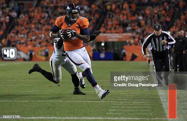Julius Thomas of the Denver Broncos sheds Kevin Burnett of the Oakland Raiders for a touchdown reception at Sports Authority Field at Mile High on...