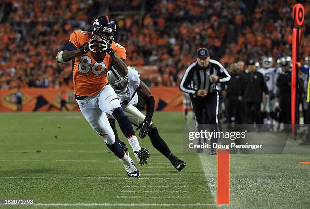 Julius Thomas of the Denver Broncos sheds Kevin Burnett of the Oakland Raiders for a touchdown reception at Sports Authority Field at Mile High on...