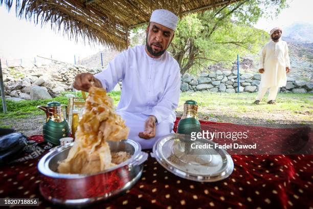 General scene of Fadel at his break, eating local bread and honey on November 29, 2023 in Sharjah, United Arab Emirates. Fadel Al-Saadi, in his...