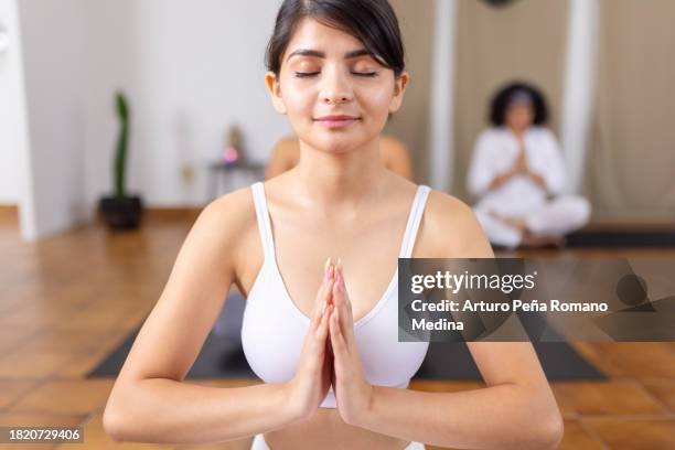 young woman meditating with hands close to heart - practice gratitude stock pictures, royalty-free photos & images