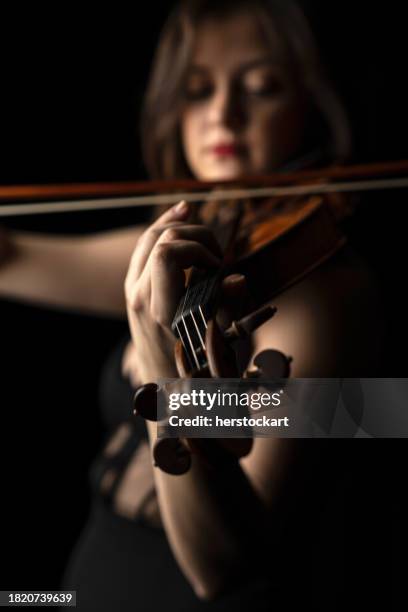 young violinist woman playing the violin - classical musician stock pictures, royalty-free photos & images