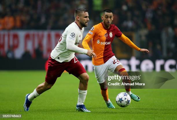 Luke Shaw of Manchester United runs with the ball whilst under pressure from Hakim Ziyech of Galatasaray during the UEFA Champions League match...