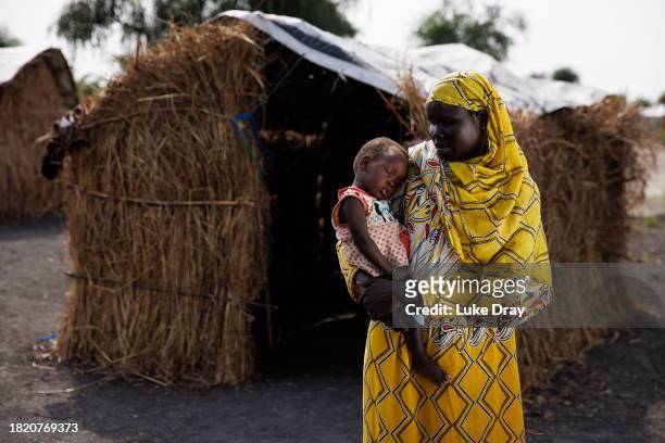 Nyekuon Gai, 40 yo, poses for a portrait with her daughter outside her shelter in an Internally Displaced Persons camp on November 29, 2023 in...