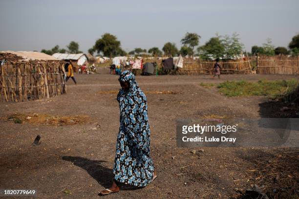 Lady walks through an Internally Displaced Persons camp on November 29, 2023 in Rotriak, South Sudan. Climate change has divided South Sudan into...