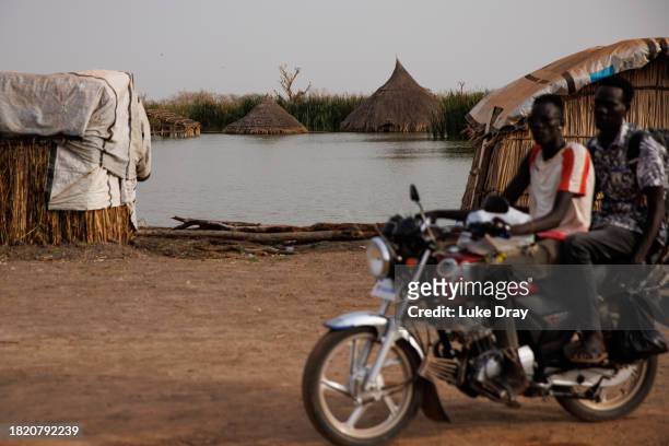 Traditional Tukul houses are partly submerged by floodwater on land that was previously a residential community on November 29, 2023 in Bentiu, South...