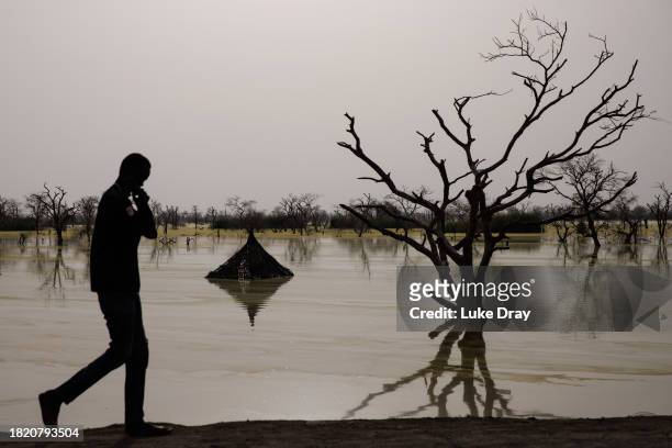Traditional Tukul houses are partly submerged by floodwater on land that was previously a residential community on November 29, 2023 in Bentiu, South...