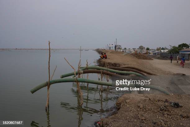Water pipes sit ready to pump out water, over a dyke, to protect Internally Displaced Persons and their host community from further flooding on...