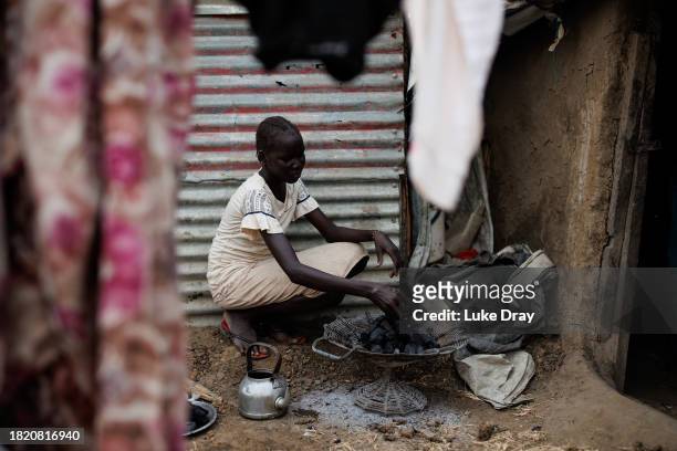 Young girl prepares a charcoal cooking stove at her home in an Internally Displaced Persons camp on November 29, 2023 in Bentiu, South Sudan. Climate...