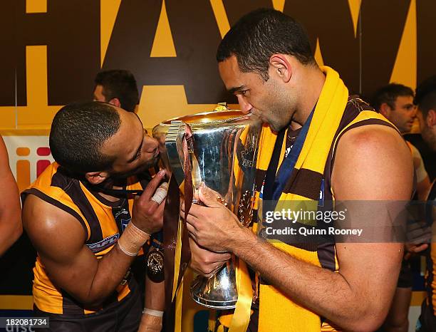 Josh Gibson and Shaun Burgoyne of the Hawks kiss the Premiership Cup after the Hawks won the 2013 AFL Grand Final match between the Hawthorn Hawks...