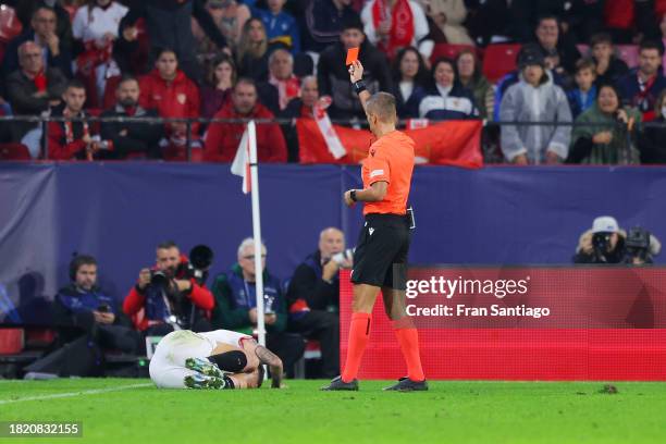 Referee Davide Massa shows a red card to Lucas Ocampos of Sevilla FC during the UEFA Champions League match between Sevilla FC and PSV Eindhoven at...