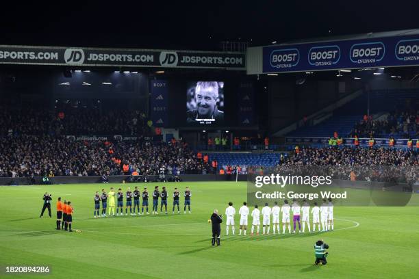 The players, fans and match officials pause for a minutes applause following the recent passing of former English football player and manager, Terry...