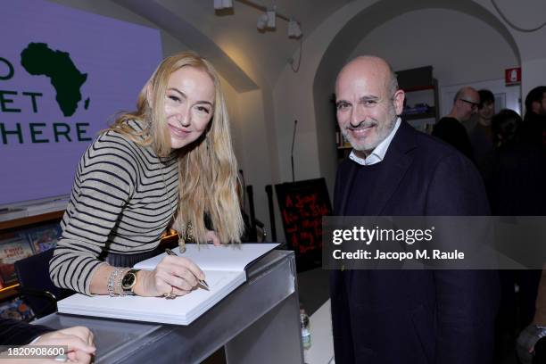 Frida Gianni autographs her book to Alessandro Maria Ferreri during Frida Giannini's "A journey into the style and music of my icons since 1969. The...