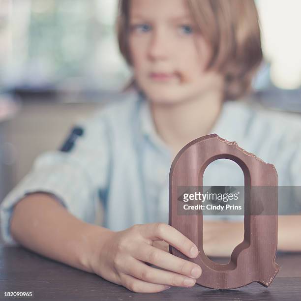 boy holding a chocolate letter - q and a foto e immagini stock