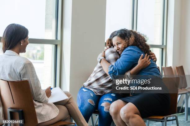 happy mom embraces unrecognizable daughter during therapy session - family mediation stock pictures, royalty-free photos & images