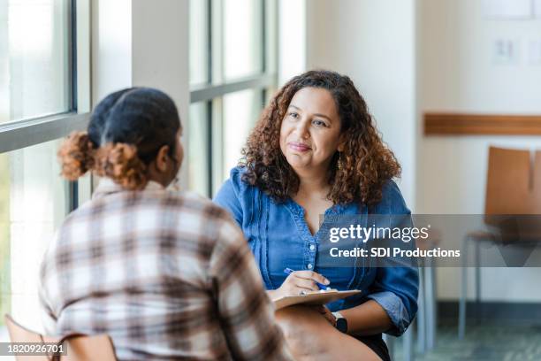 unrecognizable female university student shares struggles with female therapist - psychologie stockfoto's en -beelden