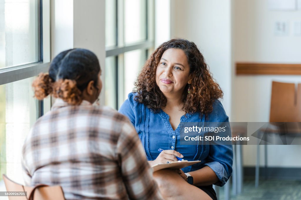 Unrecognizable female university student shares struggles with female therapist