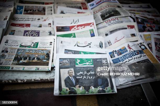 Picture shows Iranian newspapers with pictures depicting Iranian President Hassan Rouhani, US President Barack Obama, Iranian Foreign Minister...