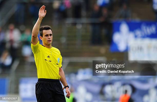 Referee Norbert Giese signals during the third Bundesliga match between 1. FC Saarbruecken and Darmstadt 98 on September 28, 2013 in Saarbruecken,...