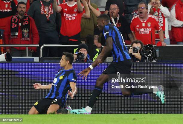 Alexis Sanchez of FC Internazionale celebrates with teammate Marcus Thuram after scoring the team's third goal from the penalty spot during the UEFA...