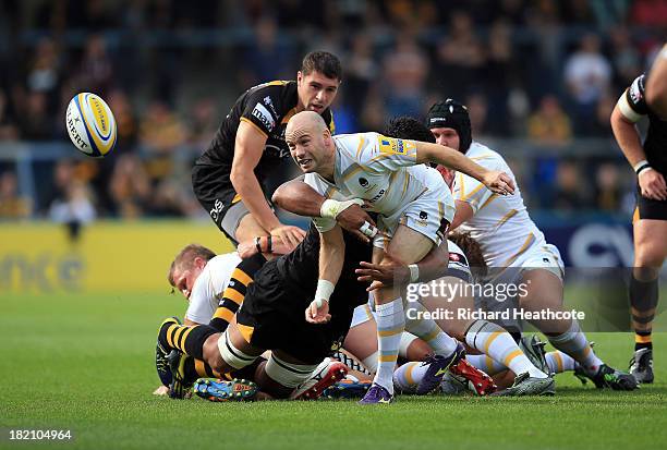 Paul Hodgson of Worcester passes the ball out under pressure from Nathan Davies of Wasps during the Aviva Premiership match between London Wasps and...