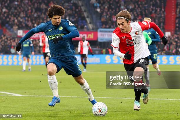 Ayase Ueda of Feyenoord is challenged by Andre Ramalho of PSV during the Dutch Eredivisie match between Feyenoord and PSV at Stadion Feijenoord on...