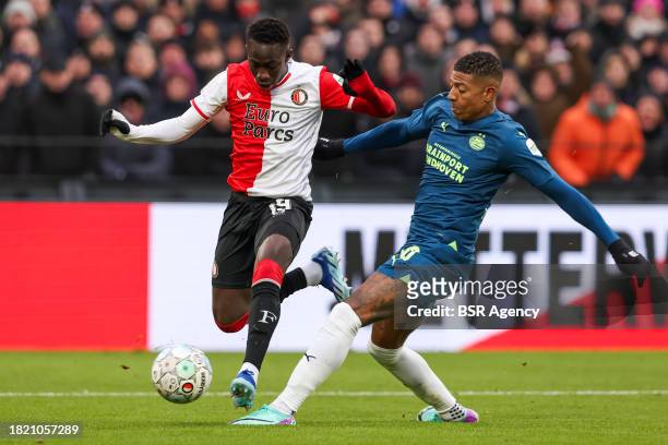 Yankuba Minteh of Feyenoord battles for the ball with Malik Tillman of PSV during the Dutch Eredivisie match between Feyenoord and PSV at Stadion...