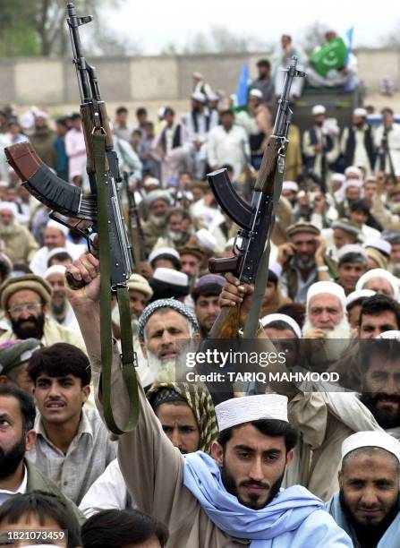 Tribesmen belong to Pakistan's fundamentalist Islamic party of Jamaat-i-Islami brandish their AK-47 assault rifles while attending a anti-war...